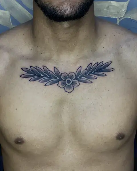 Tatuagem old school de flor e folhas no peito