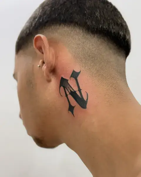 Custom lettering da inicial N em letra gótica atrás da orelha