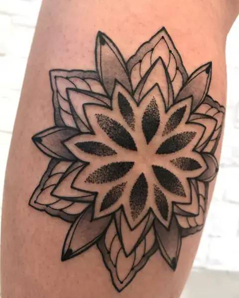 Tatuagem geométrica de mandala pontilhada na perna