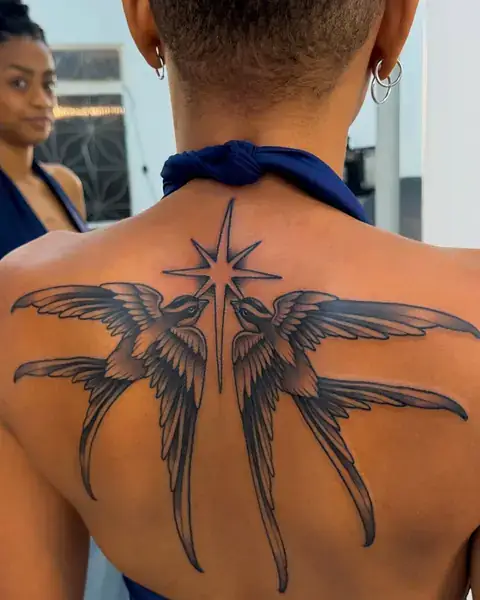 Tatuagem old school de andorinhas e estrela nas costas