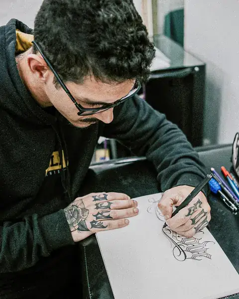 André Loureiro desenhando letras à mão no papel
