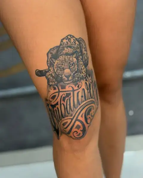 Reforma de tatuagem: onça finalizada com lettering na perna