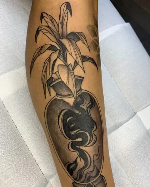 Tatuagem neotradicional de vaso com folhagem na perna